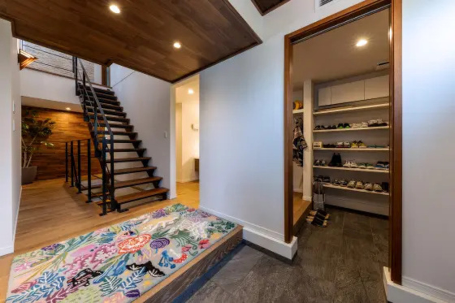 三和土（たたき）から直線の鉄骨階段を見せるようにしたのは、インダストリアルデザインにあこがれのある施主のこだわり。